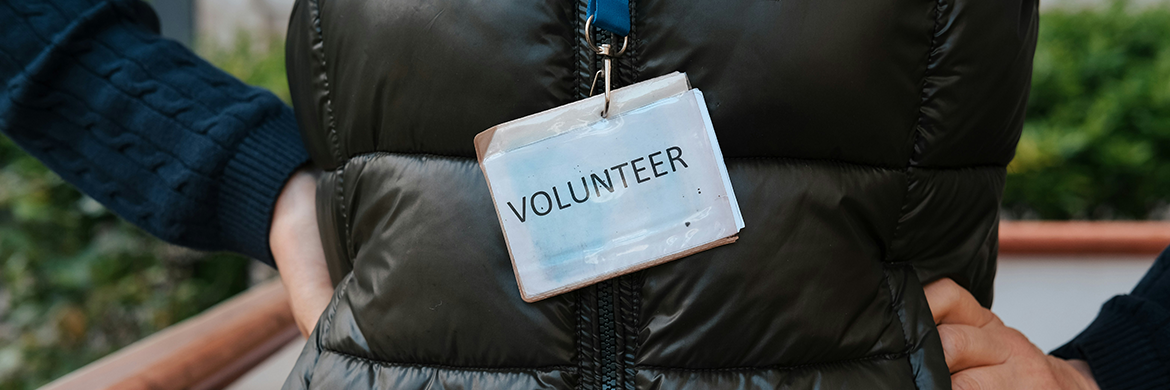 Person standing with "Volunteer" label on lanyard around their neck